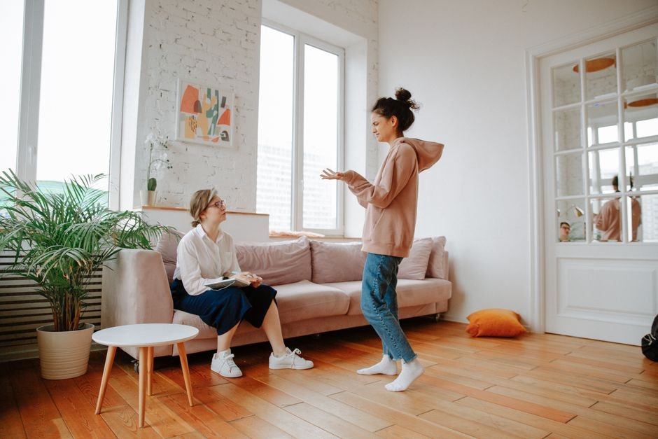 Two people in conversation in a bright room