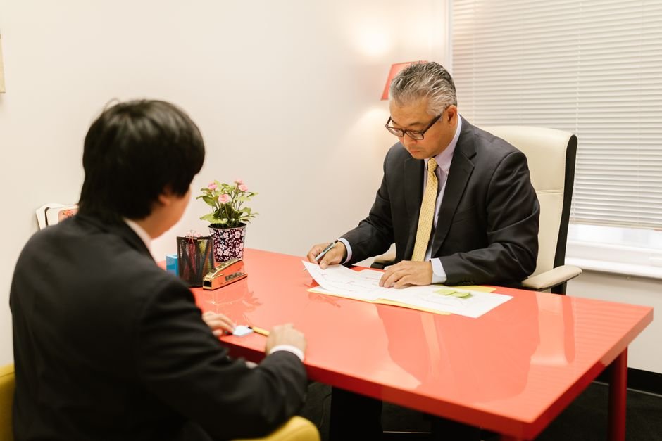 Two people talking across a desk during a consultation